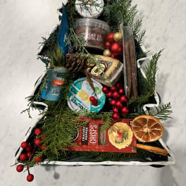 Christmas tree-shaped gift basket with snacks and ornaments