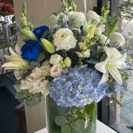 Blue and white floral arrangement in a clear glass vase