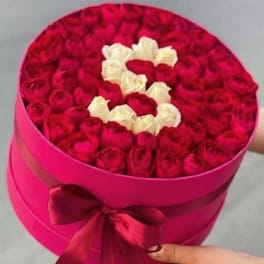Round box filled with red and white roses arranged in a heart shape