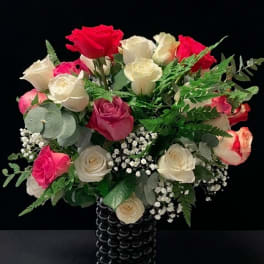 Bouquet of red, pink, and white roses in a black vase