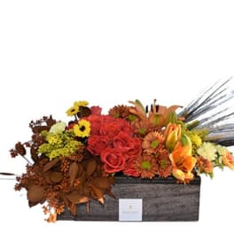 Autumn floral arrangement in a rectangular box with red roses and orange blooms