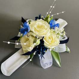 White rose corsage with blue accents and white ribbon