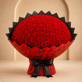 Large bouquet of red roses wrapped in red paper with black ribbon
