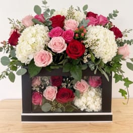 Pink and red roses with white hydrangeas in a black box arrangement