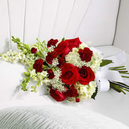 Red roses and white flowers arranged in a white chair
