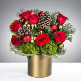 Red roses in a gold vase with pinecones and ornaments