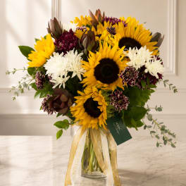 Bouquet of sunflowers and white chrysanthemums in a glass vase