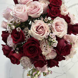 Bouquet of red and pale pink roses with small white filler flowers