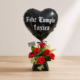 Black heart balloon above red roses in a decorative box