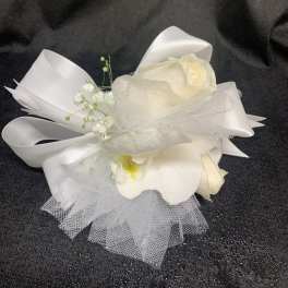 White floral wrist corsage with ribbon and tulle accents