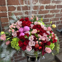 Large bouquet of red and pink roses with ornaments in a vase