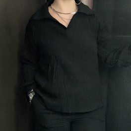 Person wearing black shirt and pants standing indoors