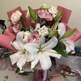 Bouquet of white lilies and pink roses wrapped in pink paper