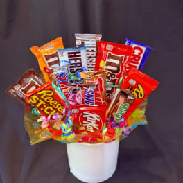 Candy bouquet in a white container with assorted chocolate bars