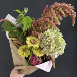 Handheld bouquet with yellow and pink flowers and pale green hydrangea