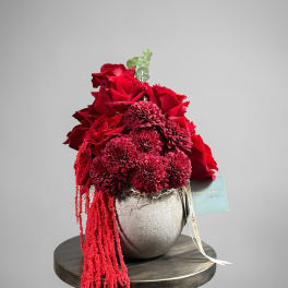 Red roses and burgundy mums arranged in a metallic vase
