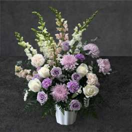 Lavender and white floral arrangement in a white vase