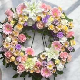 Heart-shaped floral wreath with pink, white, and lavender blooms