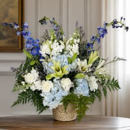 Blue and white floral arrangement in a woven basket