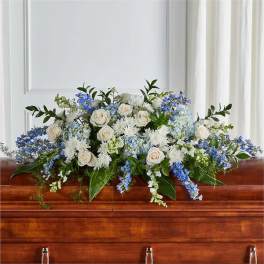 White and blue floral casket spray with roses and hydrangeas