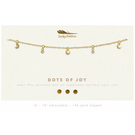 Gold charm necklace with small discs and crystal accents on a branded display card