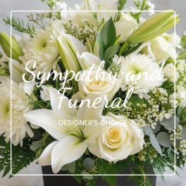 White sympathy arrangement with lilies, roses, and chrysanthemums