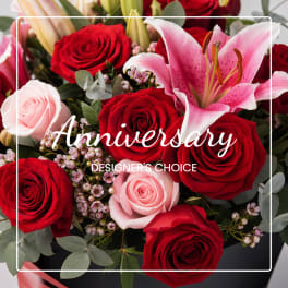 Red and pink roses with a pink lily in a black box