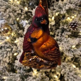 Cardinal ornament hanging on a snowy Christmas tree