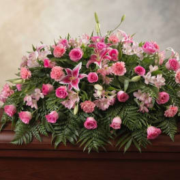 Pink floral casket spray with roses, lilies, and carnations