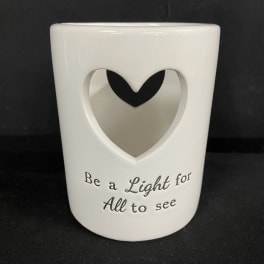 White ceramic candle holder with a heart cutout and printed text