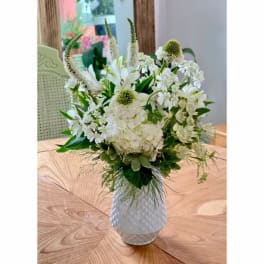 White floral arrangement in a textured white vase