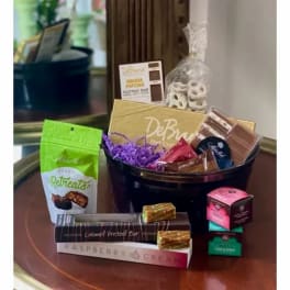Gift basket with assorted chocolates, popcorn, pretzels, and candy on a table