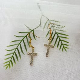 Pair of gold cross earrings with rhinestones on white mesh fabric