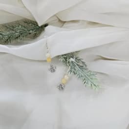 White fabric with faux greenery and dangling bee earrings
