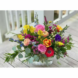 Mixed bouquet of colorful flowers in a clear glass vase