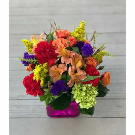 Colorful mixed bouquet in a magenta glass vase