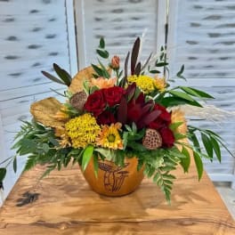 Mixed bouquet of red roses and yellow flowers in a decorative vase