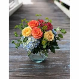 Bouquet of orange and yellow roses in a clear glass vase