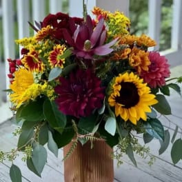 Mixed bouquet with sunflowers, dahlias, and chrysanthemums in a tall vase