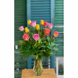 Mixed pink and yellow roses in a clear glass vase