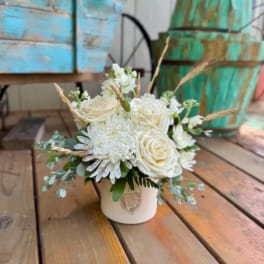 White rose and chrysanthemum arrangement in a cream vase