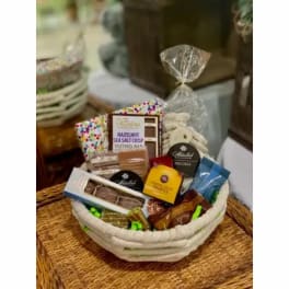 Gift basket with assorted chocolates and snacks in a woven bowl