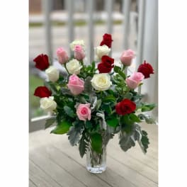 Bouquet of red, pink, and white roses in a clear glass vase