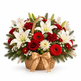Basket arrangement of red roses, white lilies, and red gerbera daisies with a gold ribbon