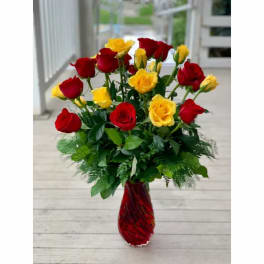 Red and yellow roses in a red glass vase