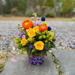 Bright mixed bouquet in a birthday container outdoors