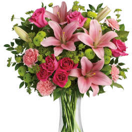 Pink lilies, roses, and carnations in a clear glass vase
