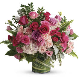 Pink and purple rose bouquet in a green glass vase