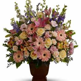 Mixed pink and cream flowers in a brown urn vase