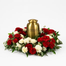 Red and white carnations arranged around a gold urn